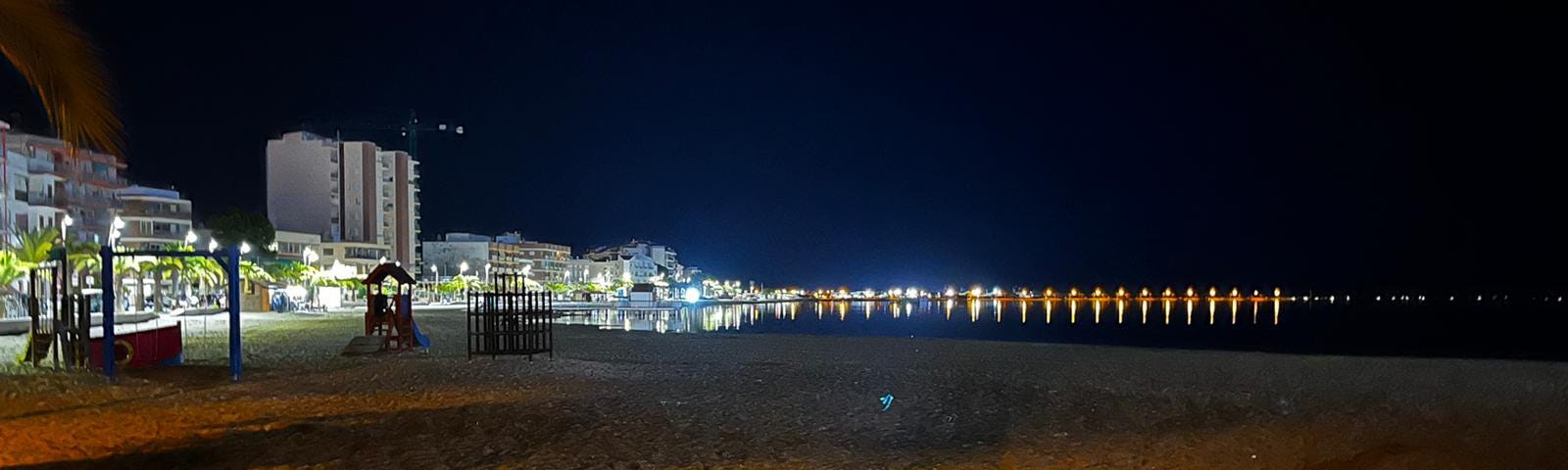 A night scene on a beach along a Spanish promenade