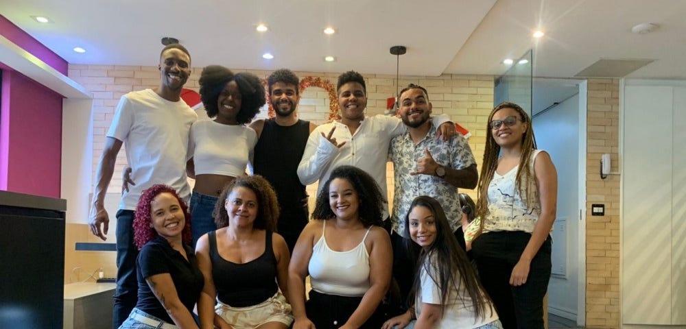 algumas pessoas que fazem parte do grupo Afro Convenia. Elas estão posando para a foto no escritório da Convenia em São Paulo.