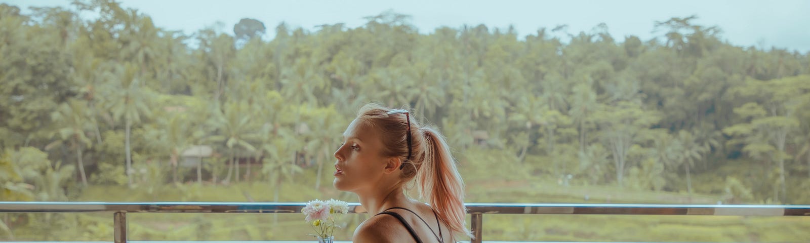 A lady sitting in a cafe overlooking a padi field.