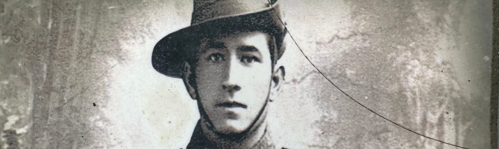 This is a close-up black-and-white photo of Cedric Popkin in uniform taken by the author at the local memorial. A small hairline crack can be seen in the photo.