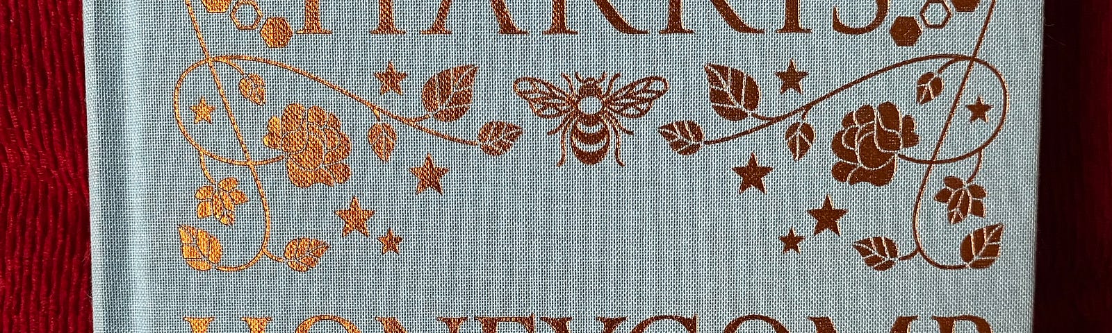 A book cover with woven plants and bees on it.