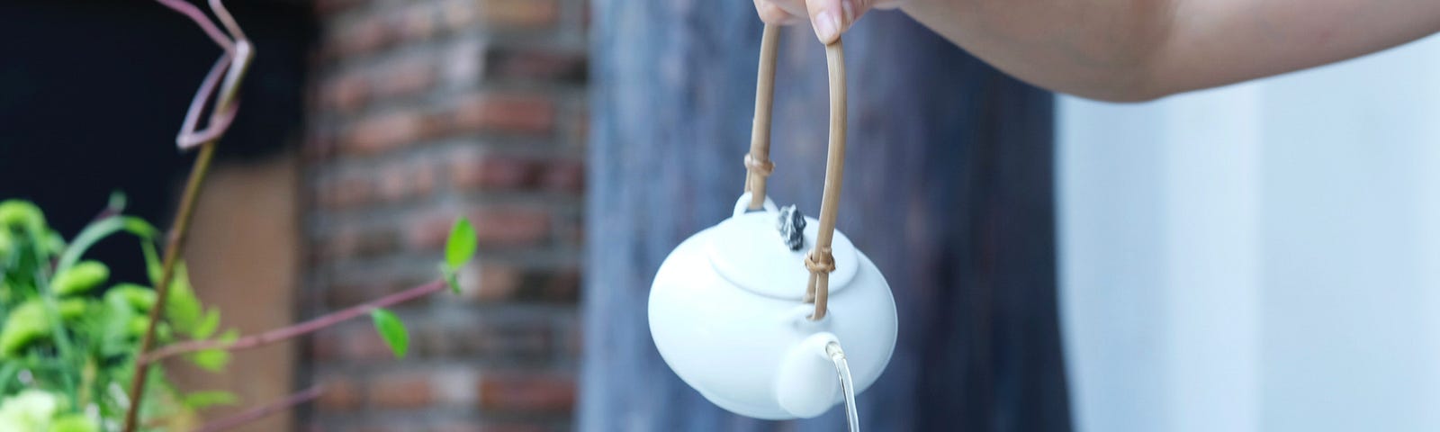 Woman pouring tea into pitcher