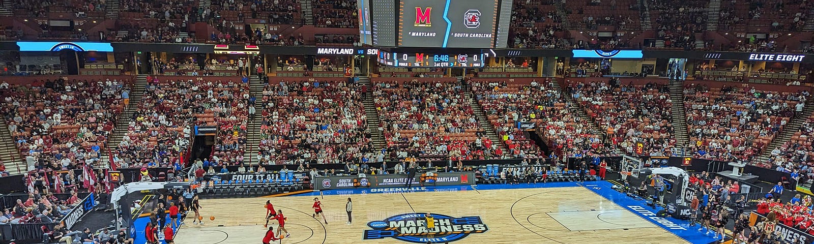 Basketball court in a crowded stadium showing women players