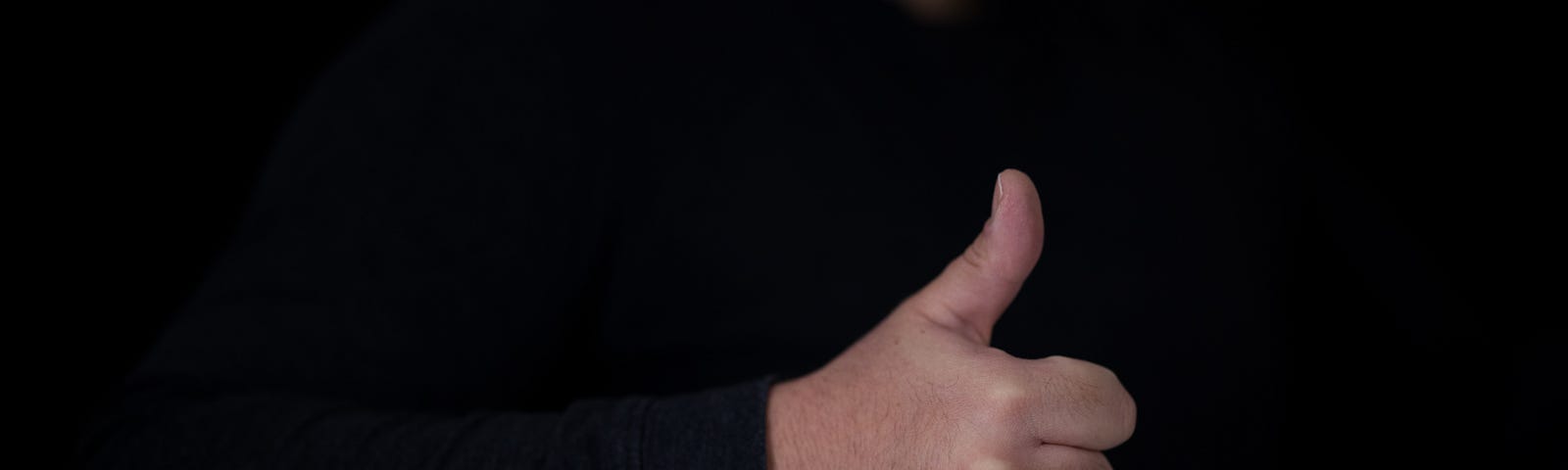 person in black long sleeve shirt giving thumbs up