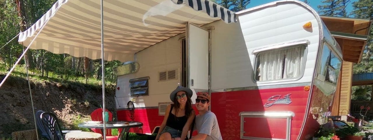 Dylan Barahona and his partner, Mo, in front of their mobile home.