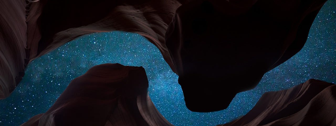 View of the starry sky, looking up from within a canyon.