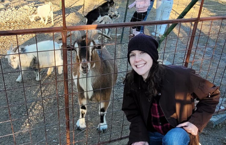 Rachelle is pictured with goats at a local family farm in Texas