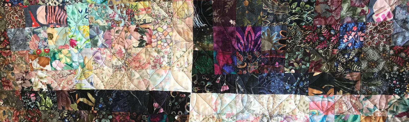 Gorgeous watercolor quilt my mom made me, with purples and pinks and greens and blues. Looks like a Marc Chagall painting.