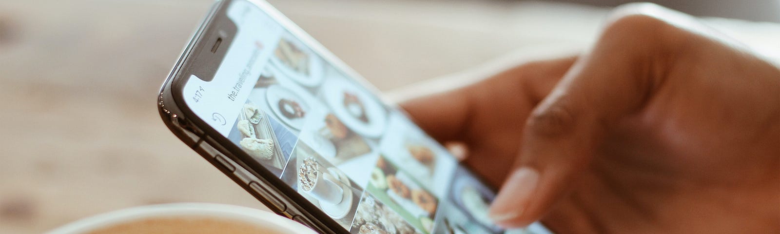 Selective Focus Photography of Person Using Iphone X with coffee on a table