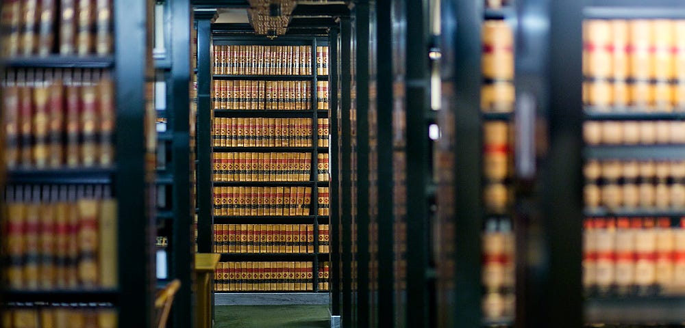 A photograph shows a green carpeted corridor and bookshelves in the Washington State Law Library at the Temple of Justice.