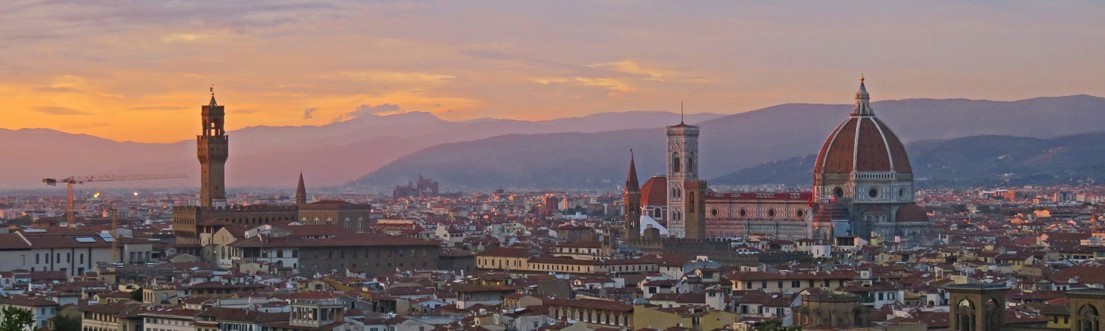 View of Florence, Italy. The buildings and the Duomo with the hills in the background as the sun is setting.
