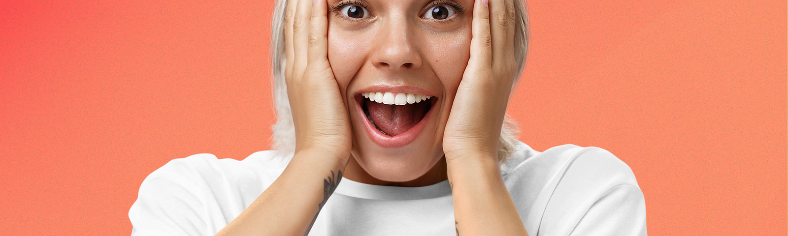 A woman holding her cheeks. She seems very surprised. She wears a shirt with the title logo “Orlando thinks #011” printed on it.