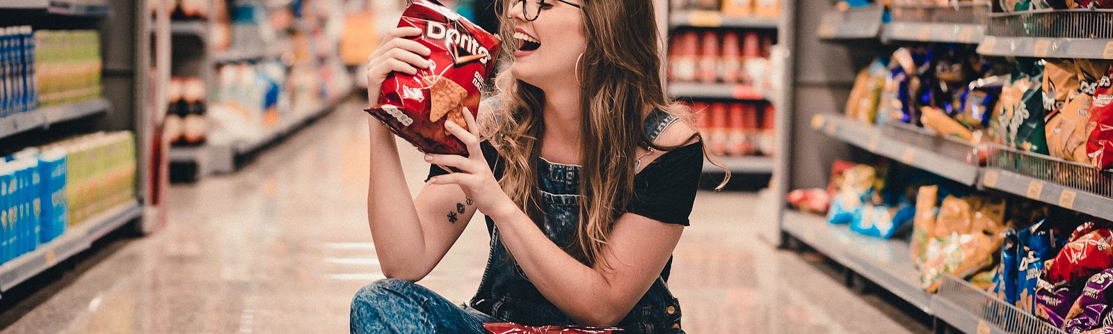 Woman eating chips in supermarket