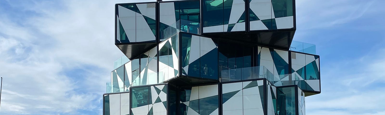 the D’Arenburg Cube — 5 storey geometric design, green and white, glass building in a vinyard