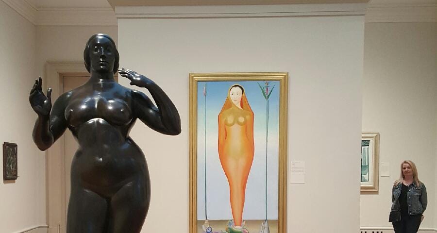 Photo taken at Art Institute, with bronze nude statue of woman in foreground, painting of a woman in a sheer, clinging dress with hood in the middle, and the author standing in the distance to the right, all in essentially the same pose.