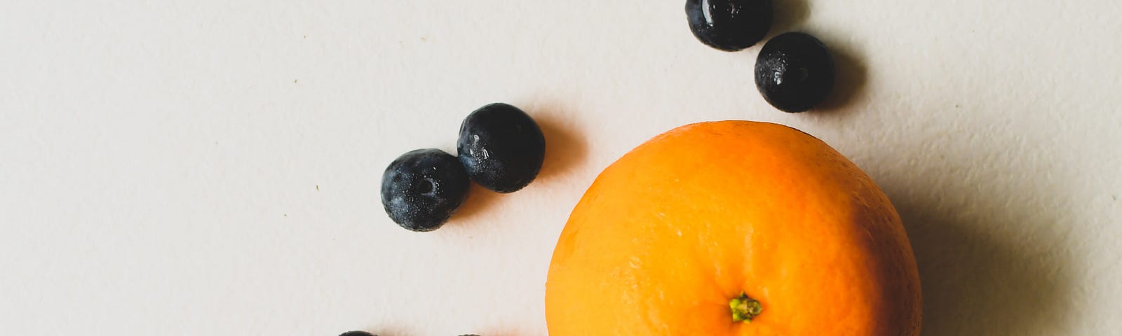 One apple, one orange, and a handful of blueberries