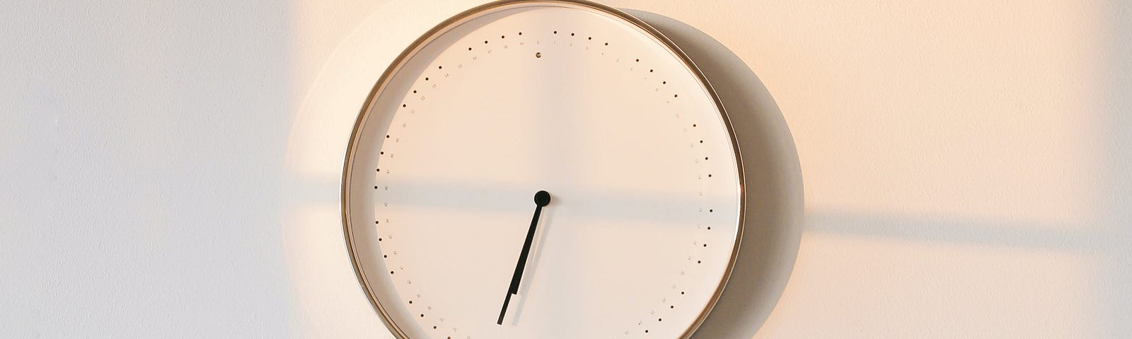 white clock face without numbers on white wall