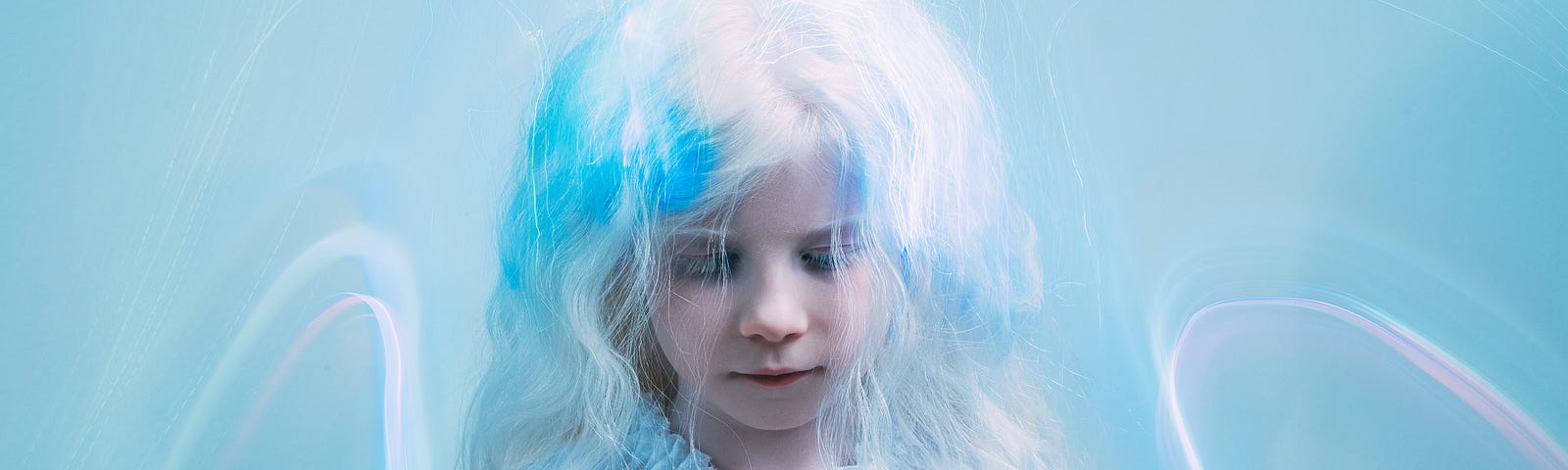 A small girl with blonde hair is looking down. The background is a pale blue with shimmers of pastels.