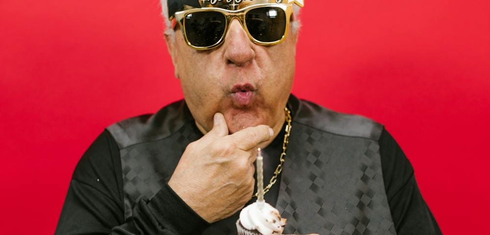 Older man looking cool while enjoying a birthday cupcake