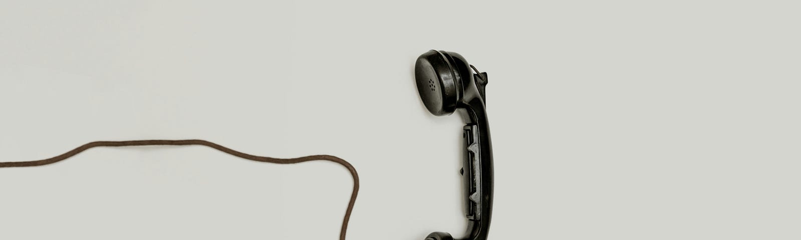Old style black telephone receiver and cord