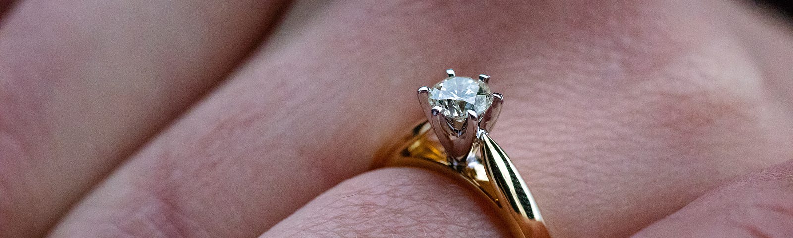 A woman’s wrinkled hand, with a diamond ring on it.