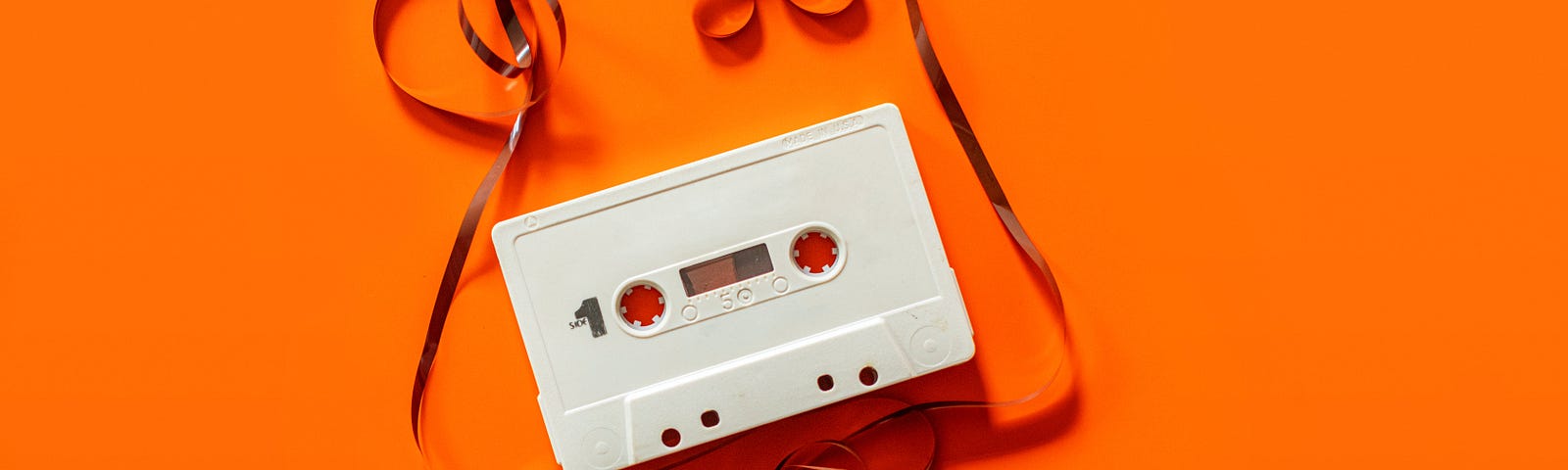 1980’s unravelled cassette tape on a bright orange background