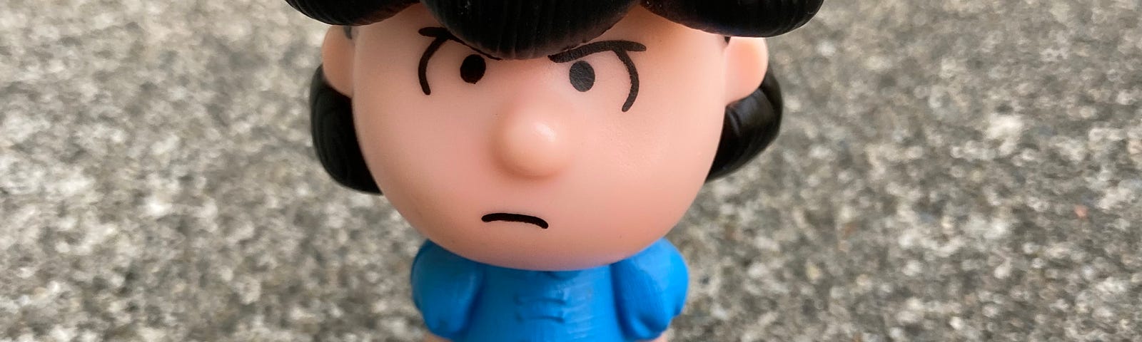 photo of a plastic toy of Lucy Van Pelt from Peanuts comics