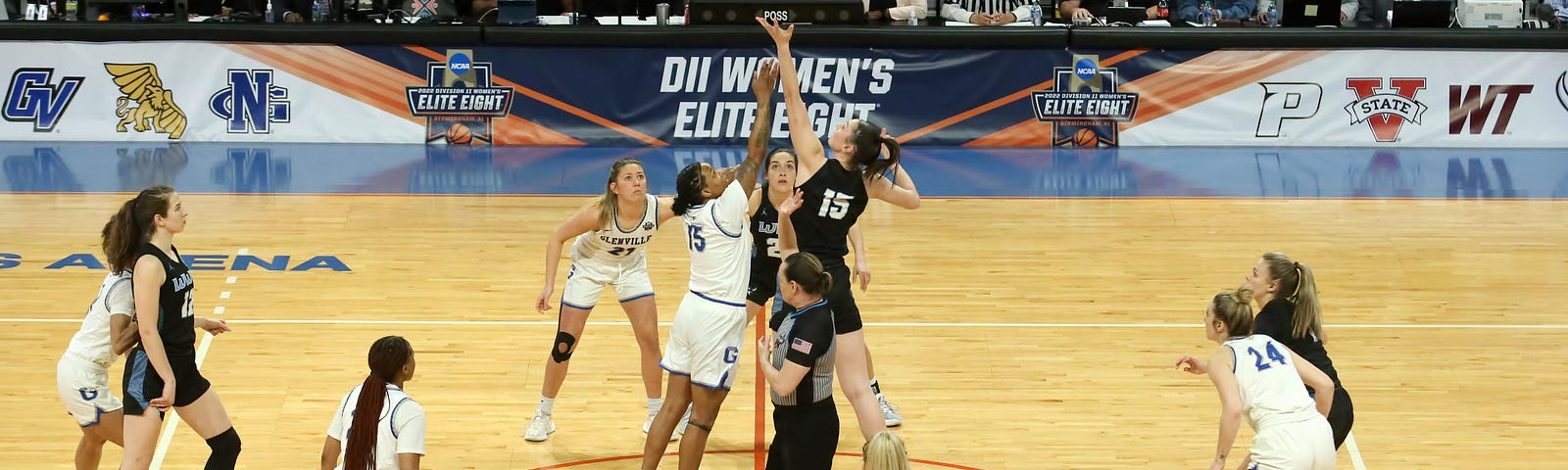 Western’s Brooke Walling competes for the jump ball in the tip-off against opponent Glenville State in the NCAA Division II Women’s Elite Eight Championship game. Both teams wait in a circle around the two players, ready to start a play.