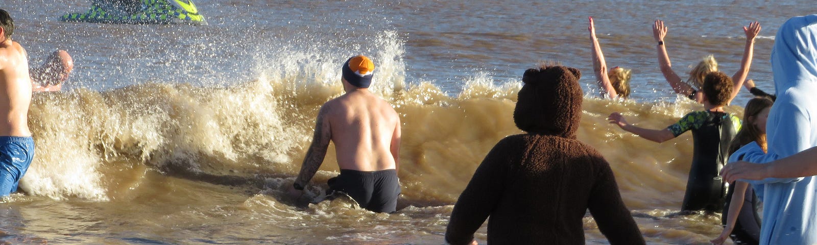 New Year’s sea bathers, some in costume — one as a cat.