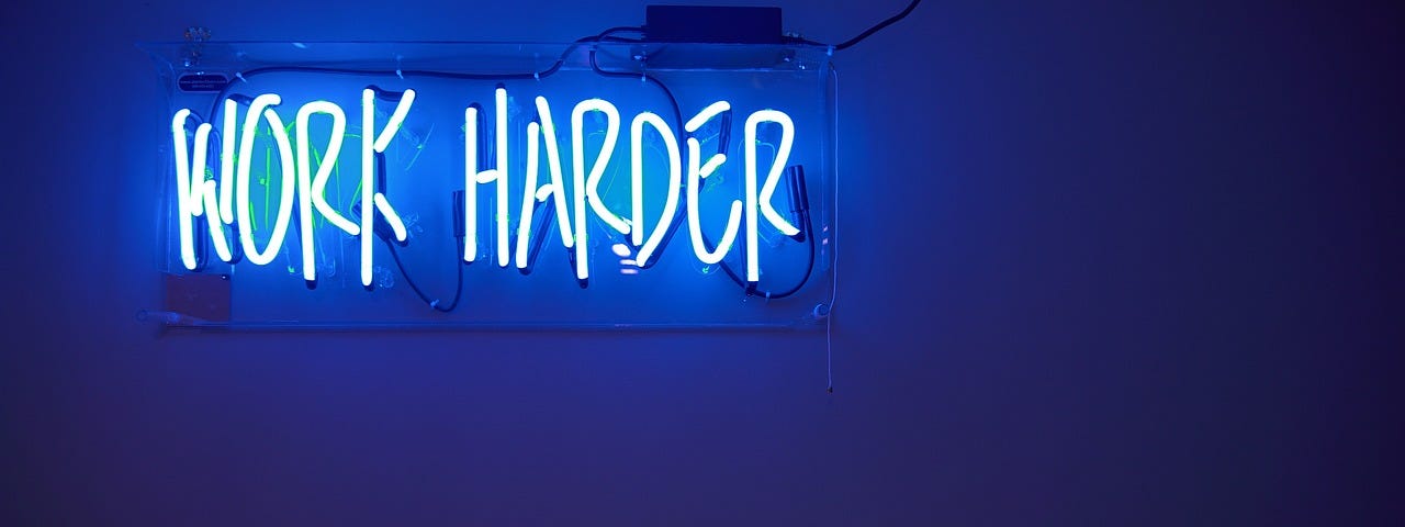 A blue wall and a sign saying ‘Work Harder’