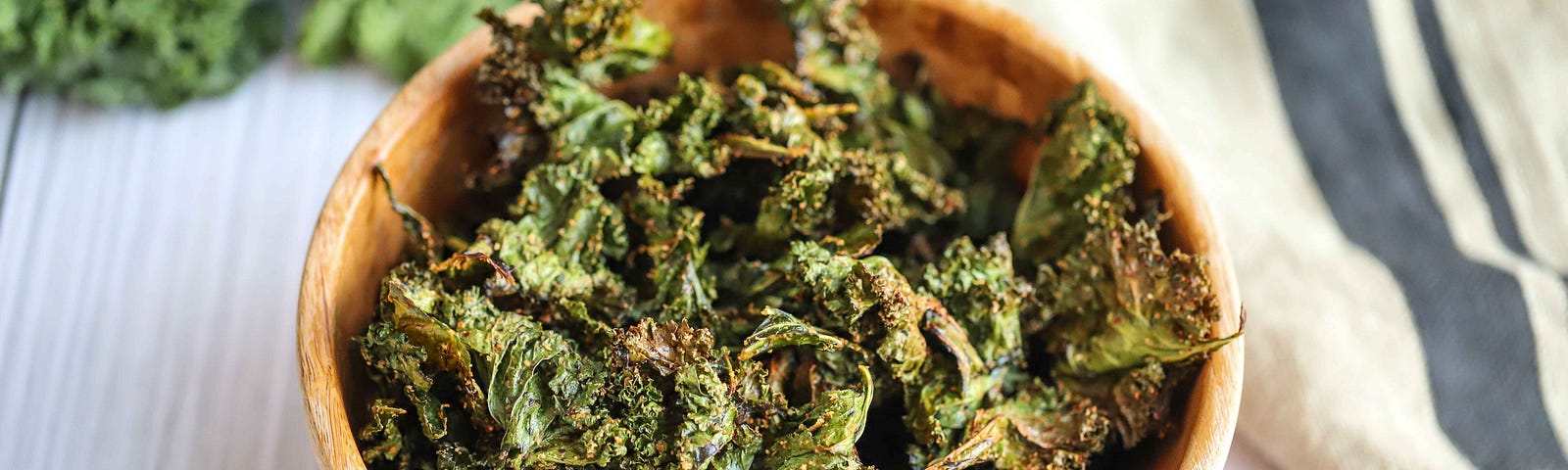 Wooden bowl filled with kale chips