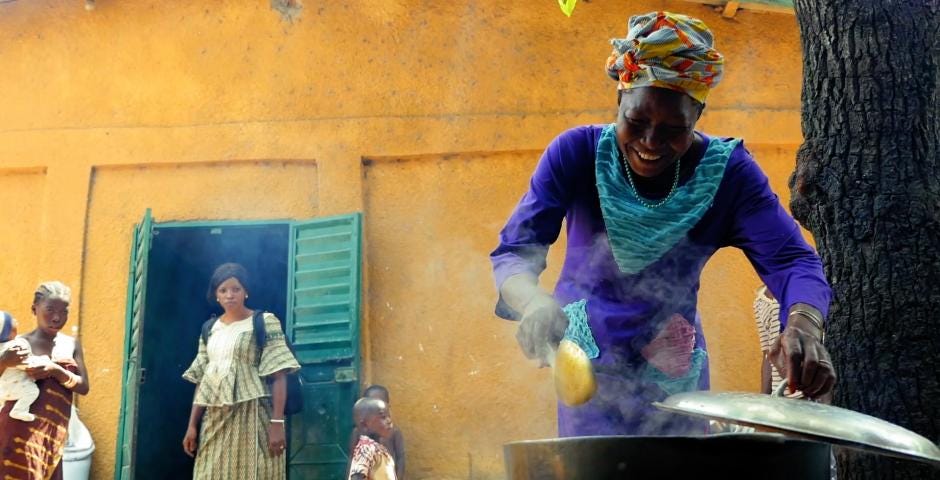 Woman cooking with a cook stove in Guinea
