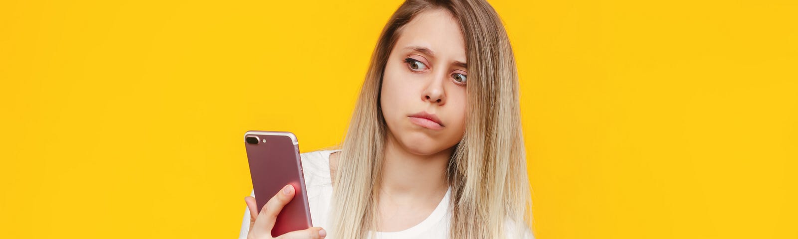 frightened-young-caucasian-blonde-woman-white-tshirt-with-mobile-phone-her-hand-looks-suspiciously-incoming-call-from-unknown-number-bright-color-yellow-wall -not-understanding— Un Swede