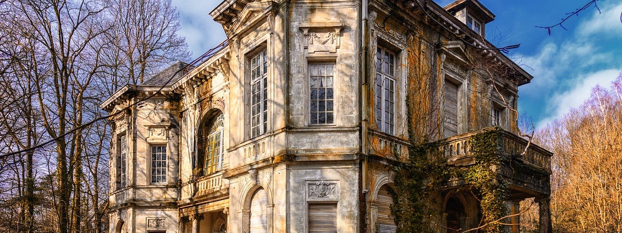 A big old house with ivy climbing up around the front door.