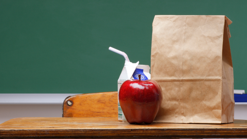 Bag Lunch with apple and milk on a school desk