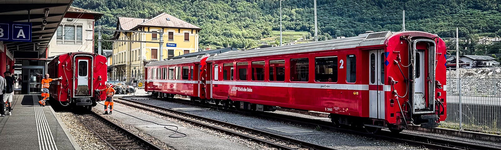 Bright red train cars in a line at the train station.