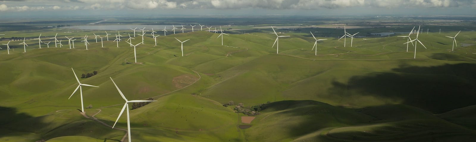 IMAGE: An aerial view of a vast green extension with many wind turbines installed