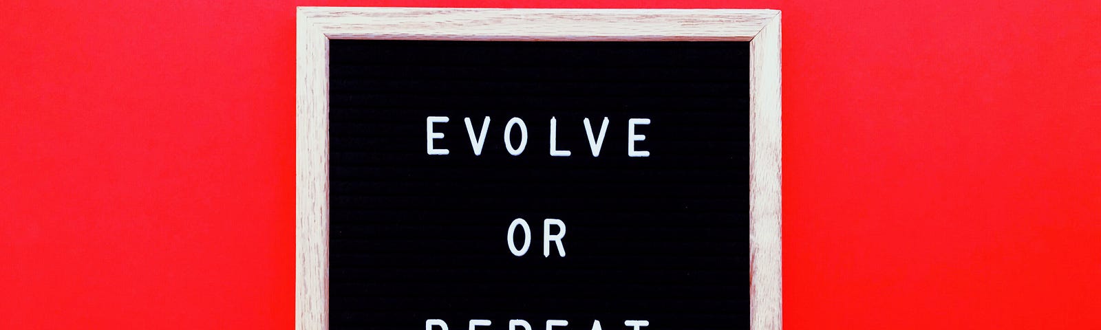 A sign reads “Evolve or repeat” against a red background.