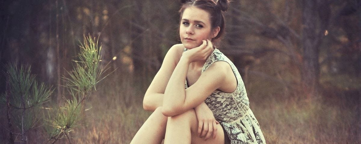 Teenage girl sitting in the woods