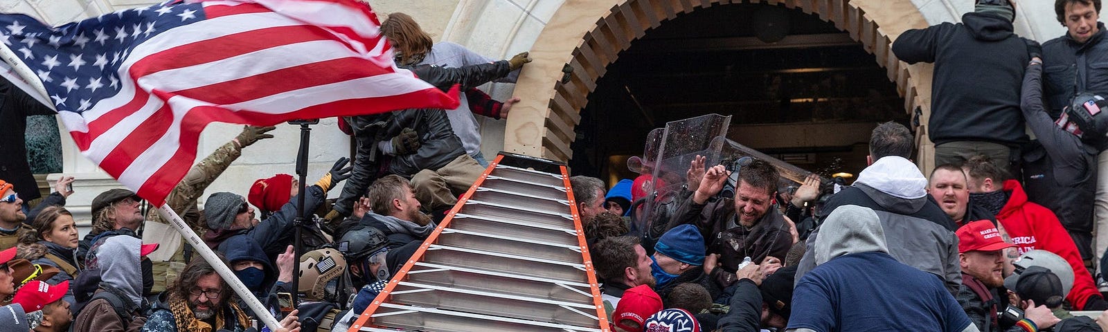 Rioters clash with police using big ladder trying to enter Capitol building through the front doors.