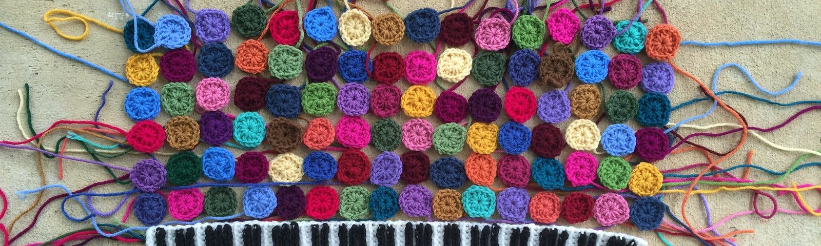 A crochet keyboard and more than one hundred one-round granny squares