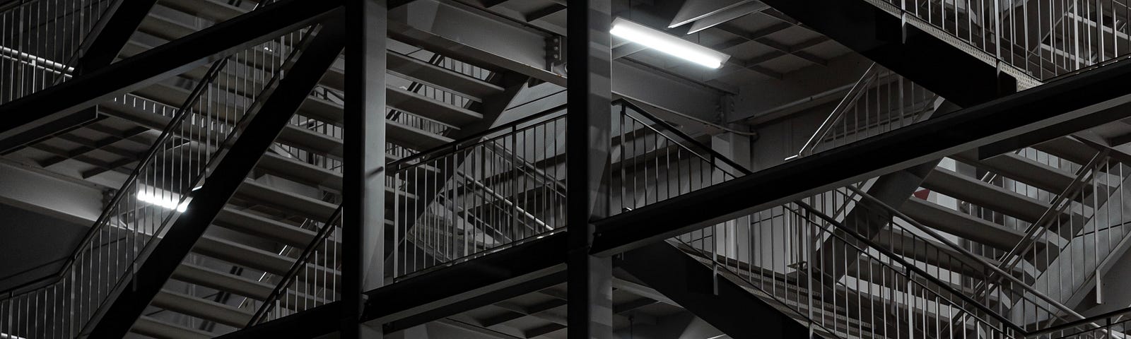 A black and white image of open steel stairs and beams