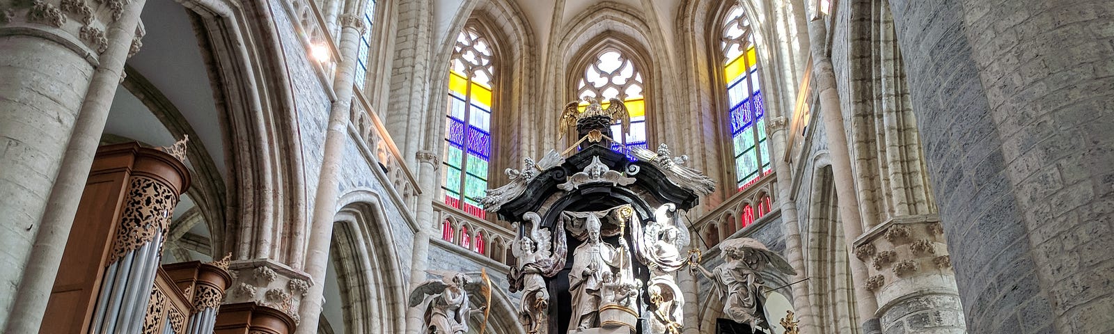 An ornate church alter with a statue of the pope on top