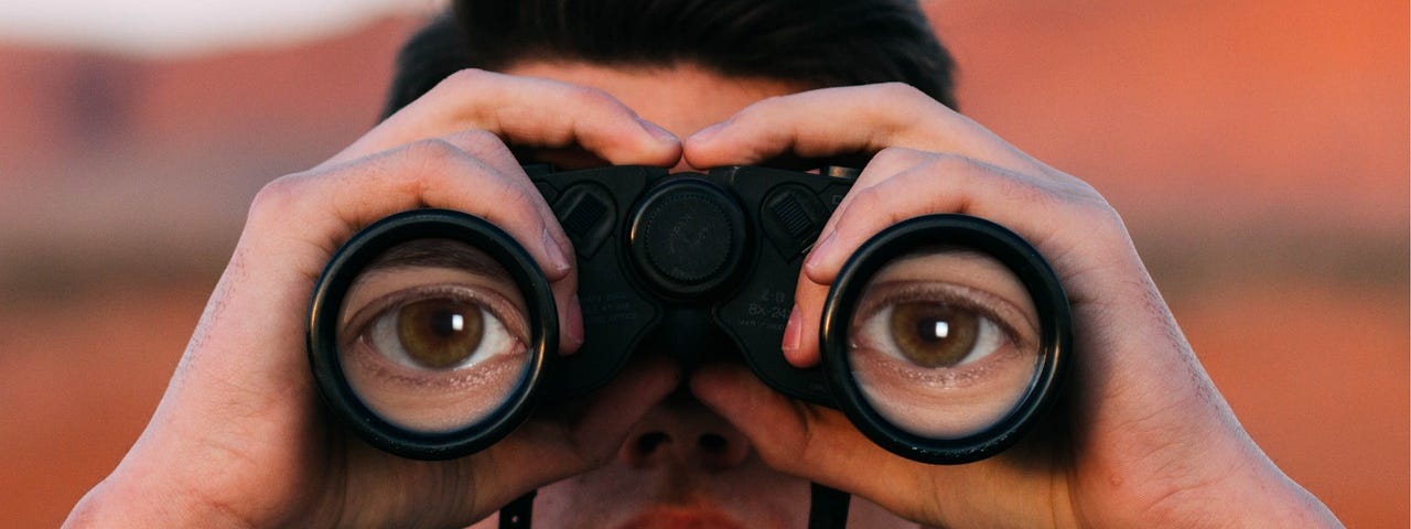 A man watching you trough binoculars.