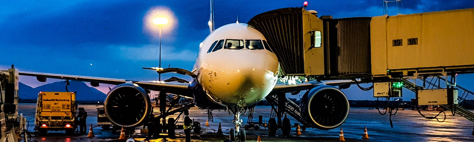 Plane at gate at airport at night.