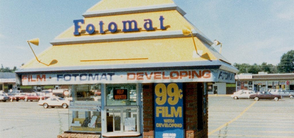 Fotomat booth in a parking lot