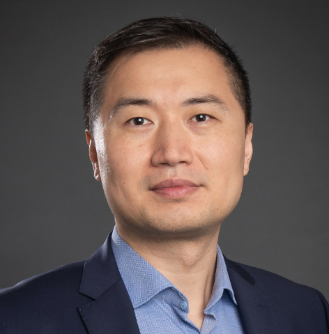 Headshot of Rex Du in a navy suit and blue shirt.