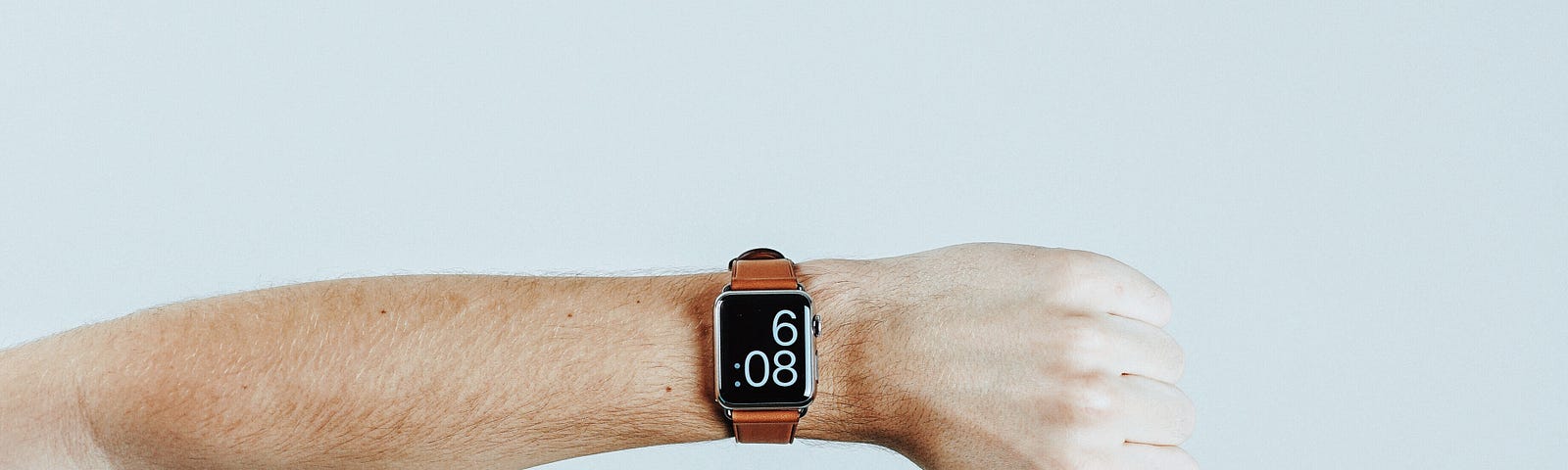 Simple picture of arm with an Apple Watch showing the time with a white background.