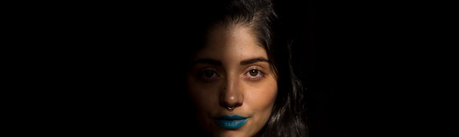 Julian Florez took this photo of a young woman with the right side of her face hidden in shadow.