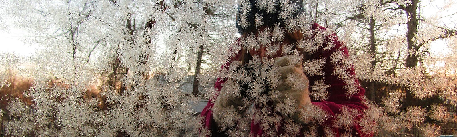 the vague shape of a person reflected in a mirror coated with frost
